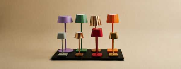 Tavellio, eight colorful wireless table lamps arranged on a single central magnetic charging station.