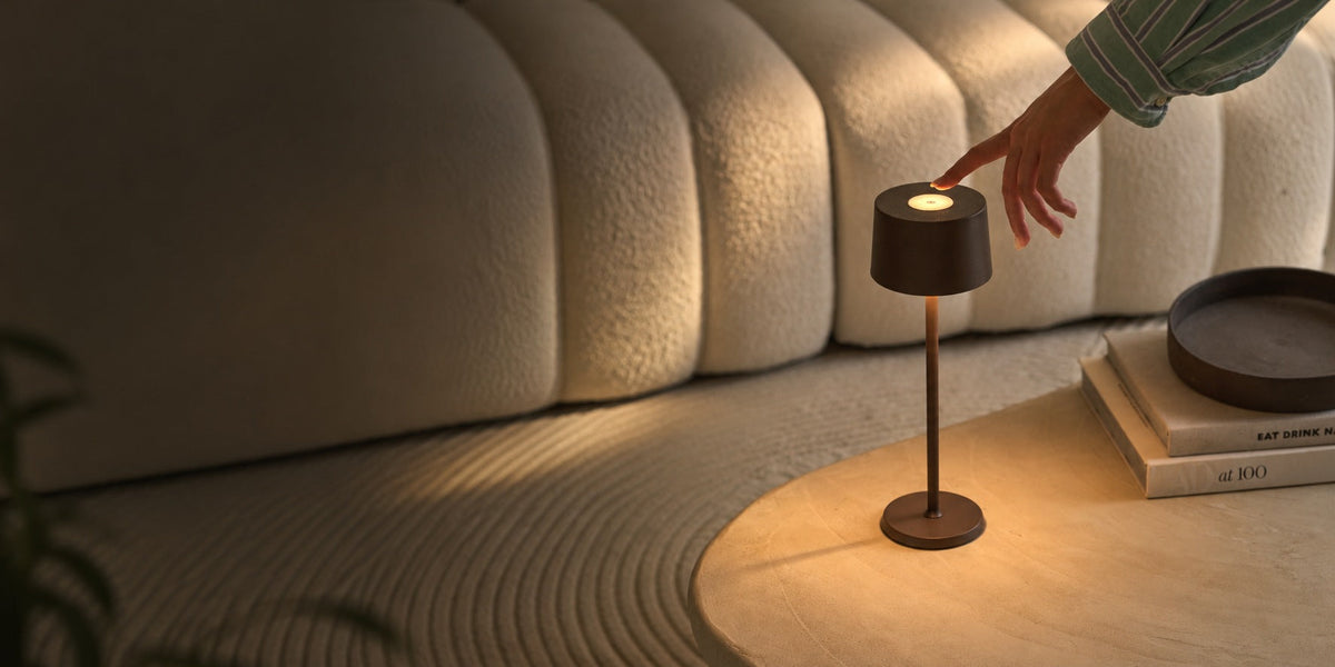 Warm rechargeable table lamp glowing in an atmospheric interior in the evening