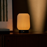 Alba Schwarz kabellose Tischlampe Tavellio – leuchtet auf Sideboard neben gerahmtem Print mit Spiegelung