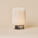 Alba rechargeable table lamp with Calacatta Viola marble base lit on a beige studio backdrop