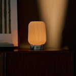 Alba rechargeable table lamp in Calacatta Vionaro marble reflected in a framed mirror on a sideboard