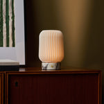 Alba cordless table lamp with dramatic Calacatta Vionaro veining on a walnut sideboard