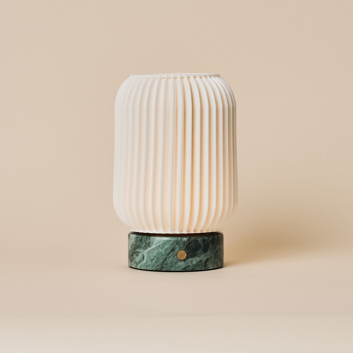 Cordless table lamp Alba with Ice Green marble base and ribbed porcelain shade on a beige backdrop