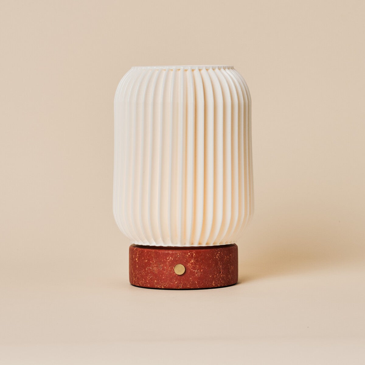 Rechargeable table lamp Alba in red travertine and porcelain, fluted shade viewed straight-on