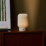 Tafellamp oplaadbaar Alba met Rosa Aurora marmer, brandend op een donker houten dressoir