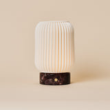 Alba cordless table lamp with Rosso Levanto marble base and fluted porcelain shade on a beige backdrop