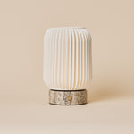 Cordless table lamp Alba in silver travertine and porcelain, fluted shade viewed straight-on