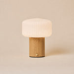 Andrew bois marron clair lampe de table sans fil Tavellio – fond studio beige – abat-jour verre opalin côtelé