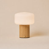 Andrew bois marron clair lampe de table sans fil Tavellio – fond studio beige – abat-jour verre opalin côtelé