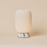 Oplaadbare tafellamp Aurora Arabescato marmer en porselein op een beige studioachtergrond