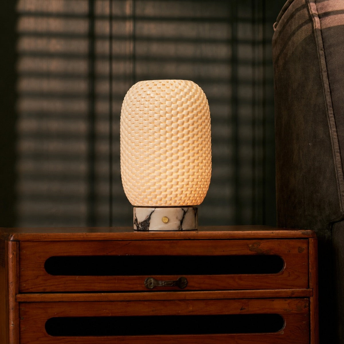 Rechargeable table lamp Aurora in Calacatta Vionaro marble and porcelain lit on a wood credenza beside framed wall art