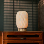 Aurora cordless table lamp in yellow Calacatta Vionaro marble lit beside striped window blinds