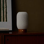 Aurora Chestnut Brown rechargeable lamp unlit, its textured porcelain shade on a dark wood cabinet