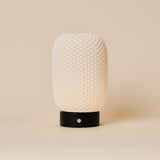 Aurora rechargeable table lamp with woven porcelain shade on a black Nero Marquina marble base