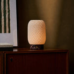 Aurora rechargeable table lamp casting warm light on a wooden sideboard beside a striped art print