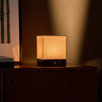 Barent marbre Emperador Dark lampe de table sans fil Tavellio - éclairant une commode en bois foncé au crépuscule - lumière chaude en dégradé