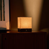 Barent marbre Emperador Dark lampe de table sans fil Tavellio - éclairant une commode en bois foncé au crépuscule - lumière chaude en dégradé