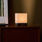 Barent marbre Emperador Dark lampe de table rechargeable Tavellio - posée sur une commode près d'une serrure en laiton - faisceau lumineux chaud