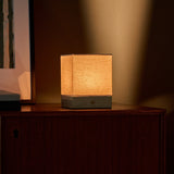 Barent travertin Classic lampe de table rechargeable Tavellio - posée sur un buffet en bois près d'une serrure - lumière chaude en dégradé