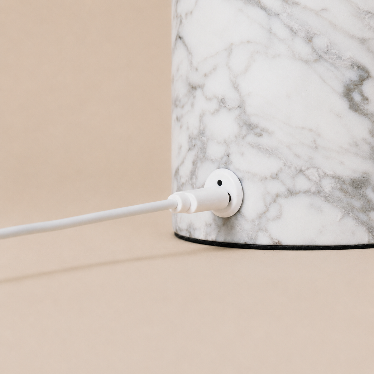 Magnetic charging cable connected to the Hooch Small Bianco Statuarietto marble lamp base