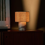 Bonnard cordless table lamp glowing warmly on a dark wood cabinet with brass control button
