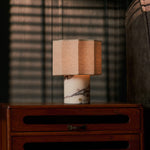 Bonnard cordless table lamp glowing on a wooden nightstand beside sunlit blinds in a bedroom