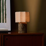 Tavellio Bonnard Large rechargeable table lamp lit on a walnut cabinet beside a green striped artwork