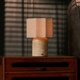 Bonnard Large travertin beige lampe de table rechargeable Tavellio – devant des stores vénitiens, près d'un fauteuil rayé rose et gris