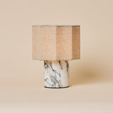 Bonnard rechargeable table lamp in Arabescato marble with a striped linen shade on a beige backdrop