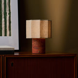 Bonnard rechargeable table lamp in Red Travertine stone on a teak sideboard beside green striped wall art