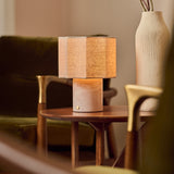 Bonnard Rosa Aurora lampe de table rechargeable Tavellio – sur une table basse en bois – vase en céramique à proximité