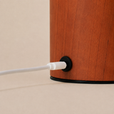 Magnetic charging cable connecting to the chestnut wood base of the Aurora rechargeable lamp