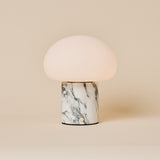 Rechargeable table lamp with a dome shade on an Arabescato marble base with grey veining, studio shot