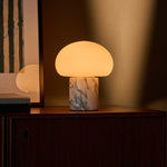 Tavellio cordless table lamp with an Arabescato marble base glowing softly on a credenza at dusk