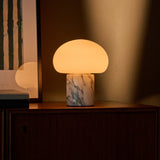 Tavellio cordless table lamp with an Arabescato marble base glowing softly on a credenza at dusk