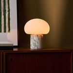 Rechargeable table lamp with an Arabescato marble base lit on a walnut sideboard beside abstract wall art