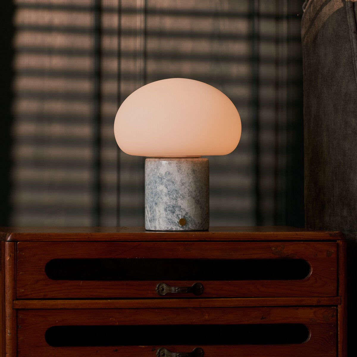 Codde Blue Calcite marbre lampe de table sans fil Tavellio – allumée sur une commode en bois, ombres de store rayé le soir