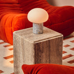 Codde Blue Calcite marbre lampe de table rechargeable Tavellio – posée sur un cube en pierre à côté d un canapé orange brûlé