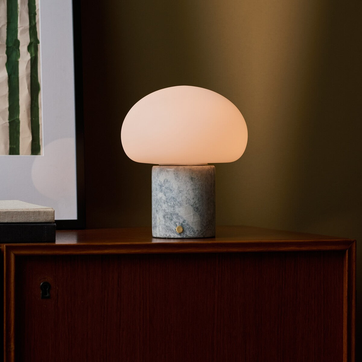 Codde Blue Calcite marbre lampe de table sans fil Tavellio – allumée sur l angle d un buffet en bois, mur olive en fond