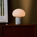 Codde Blue Calcite marbre lampe de table sans fil Tavellio – allumée sur l angle d un buffet en bois, mur olive en fond