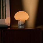 Codde cordless table lamp with mushroom-dome shade glowing warmly against a dark green wall