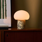 Codde marbre jaune Calacatta Vionaro lampe de table sans fil Tavellio – posee sur un meuble en bois pres d une oeuvre a rayures – reflet dans le miroir a gauche