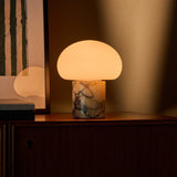 Codde marbre jaune Calacatta Vionaro lampe de table sans fil Tavellio – posee sur un meuble en bois pres d une oeuvre a rayures vertes – lumiere diffusee par le dome
