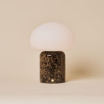 Coddé Large marbre Emperador foncé lampe de table sans fil Tavellio – photo en studio, fond beige uni – abat-jour dôme en verre opalin blanc