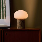 Coddé Large marbre Emperador foncé lampe de table sans fil Tavellio – buffet en bois foncé devant un mur vert olive – serrure à clé visible