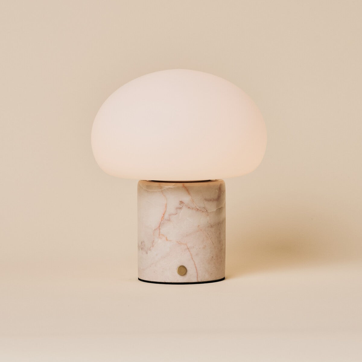 Coddé Rosa Aurora marbre rose lampe de table sans fil Tavellio – photo studio sur fond beige – globe en verre dépoli bombé