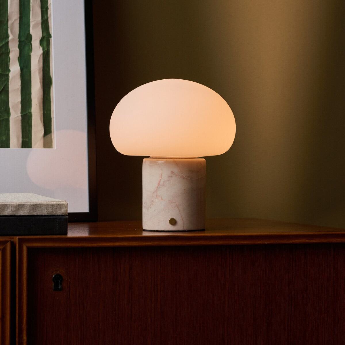 Coddé Rosa Aurora marbre rose lampe de table rechargeable Tavellio – cadrage rapproché sur le meuble – tissu à rayures visible à droite