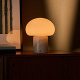 Coddé Rosa Aurora marbre rose lampe de table sans fil Tavellio – sur un meuble en bois foncé – tableau à rayures vertes en arrière-plan