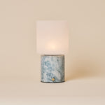 Cuyp Blue Calcite Marble Rechargeable Table Lamp glowing on a cream studio backdrop