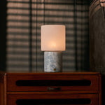 Tavellio rechargeable table lamp on a bedroom nightstand with sunlit blind shadows